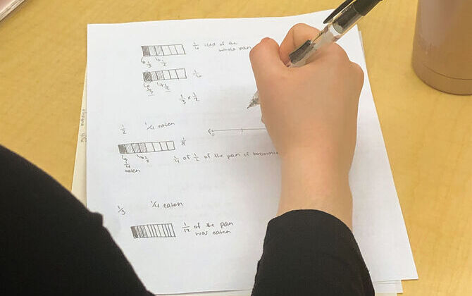 Student holding pen while completing a worksheet